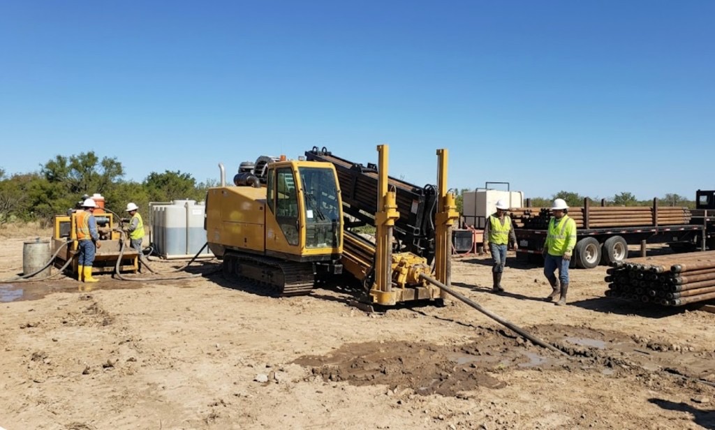 Directional drilling in Amarillo, TX — directional drilling rig with mud mixing system and crew on active Texas bore site